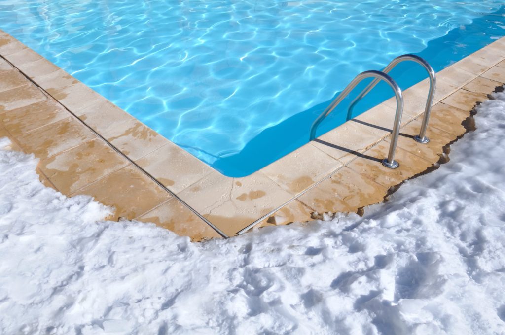 A pool in the winter with snow around it